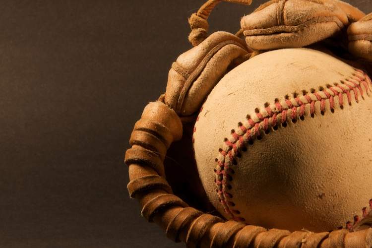A baseball cradled in a baseball glove