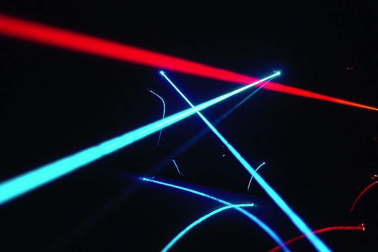 Different colored laser beams intersect in the darkness