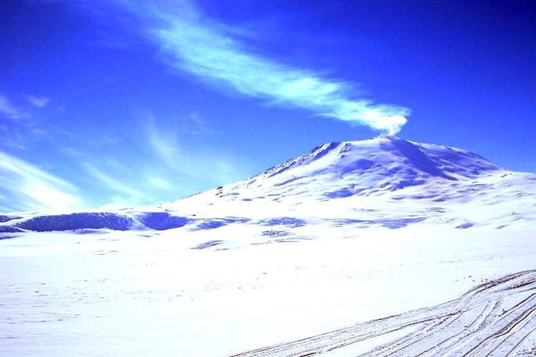 Mt. Erebus steams against a blue sky
