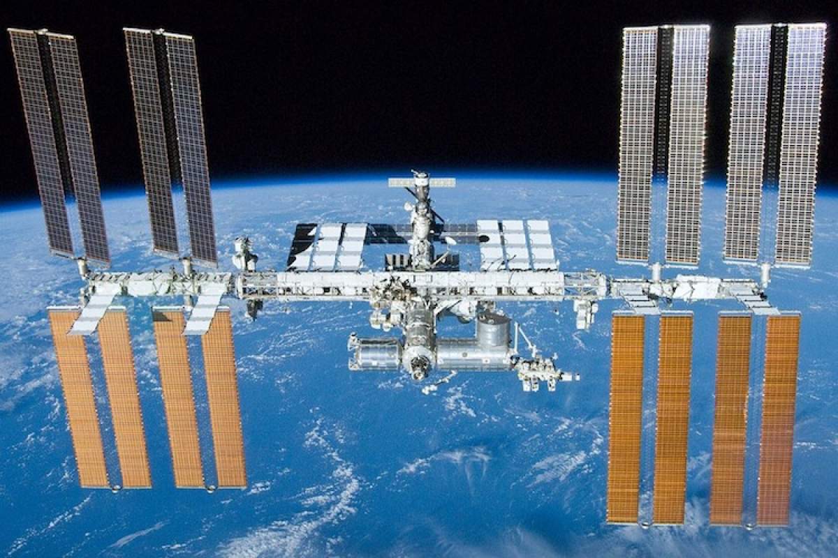 Photo of the International Space Station with Earth behind.