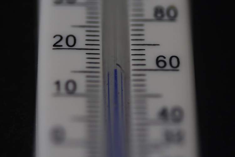 A thermometer with blue fluid reads 60 degrees Fahrenheit.