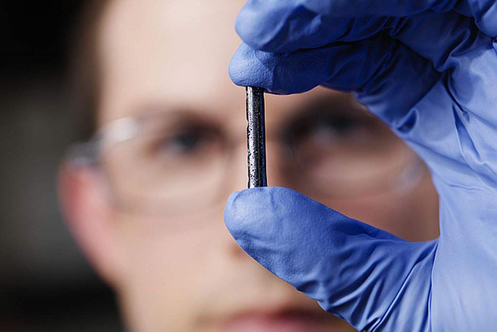 A researcher holds a bulk compound semi-conductor synthesized for photovoltaic devices.