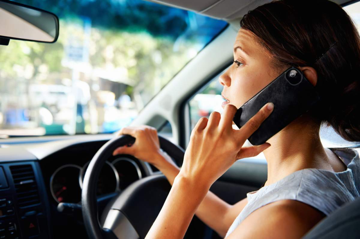 woman drives while talking on cell phone