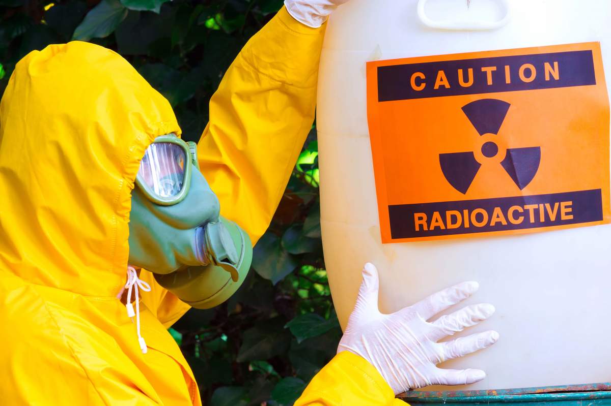 person in haz-mat suit handling radioactive material