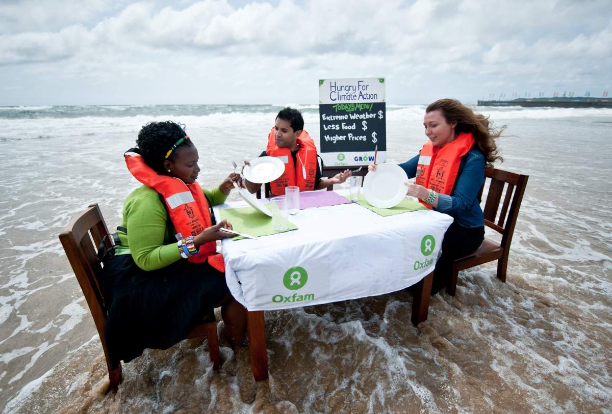 3 women in life vests sit at dinner table on the shore