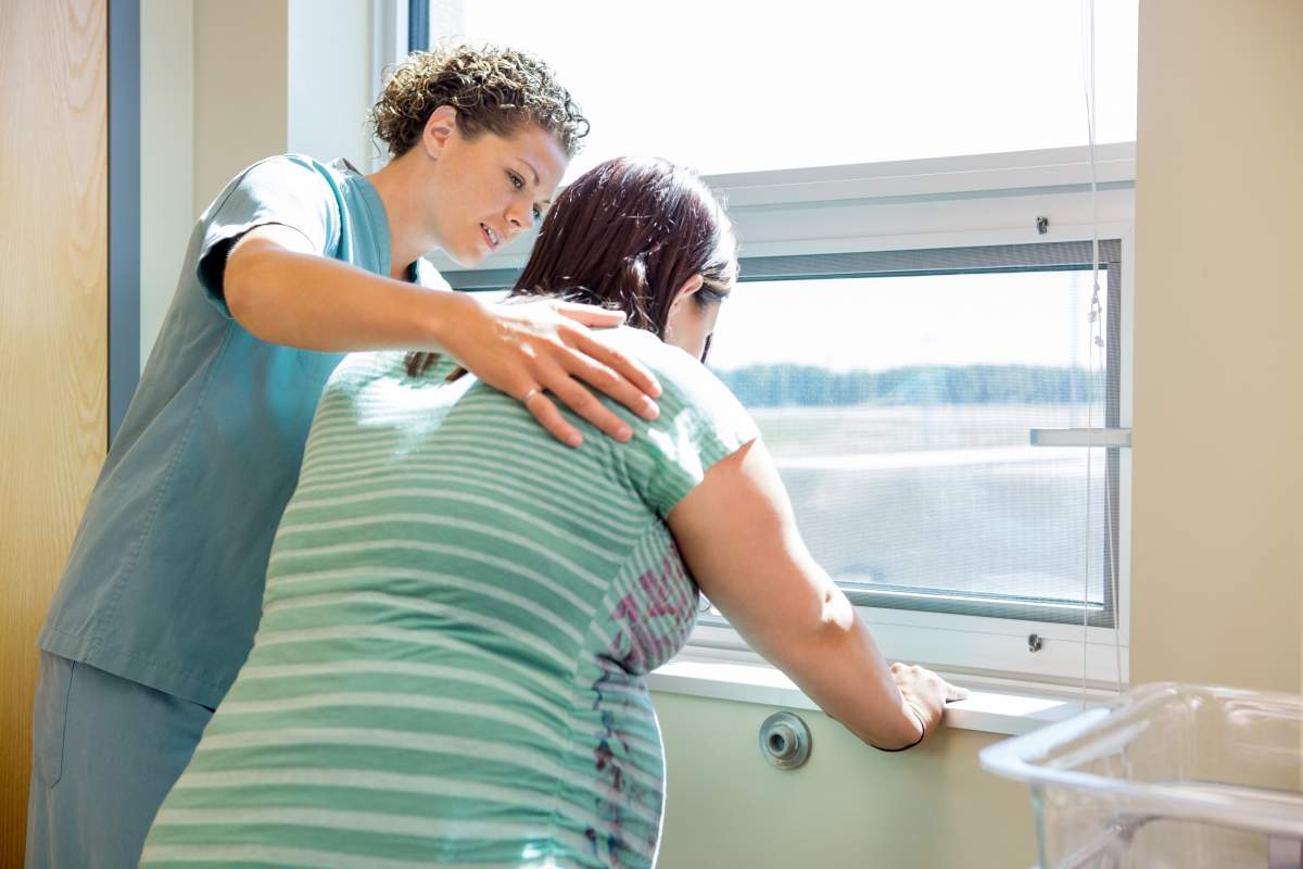 nurse assists pregnant woman