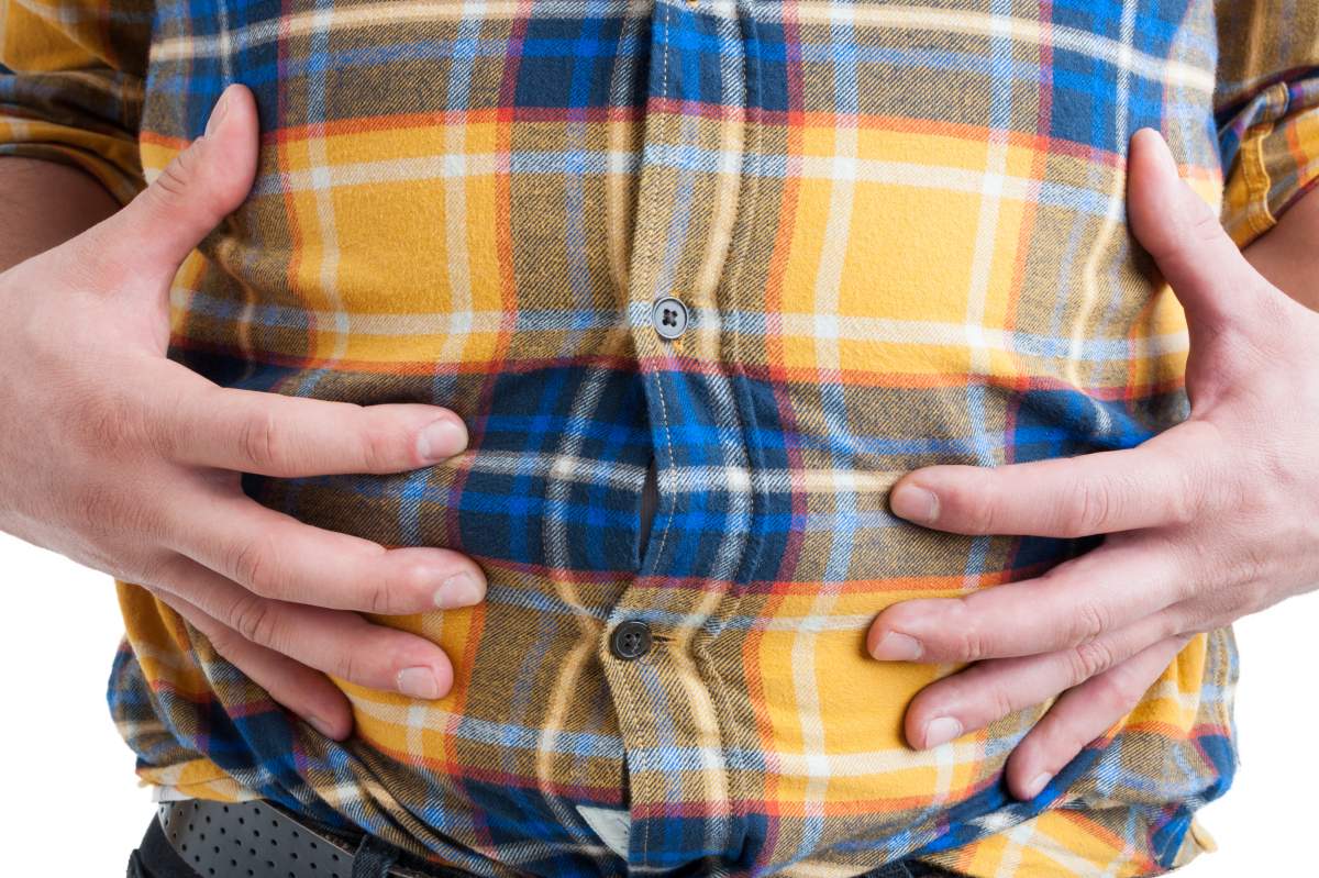 man holds stomach, gesturing that he's full
