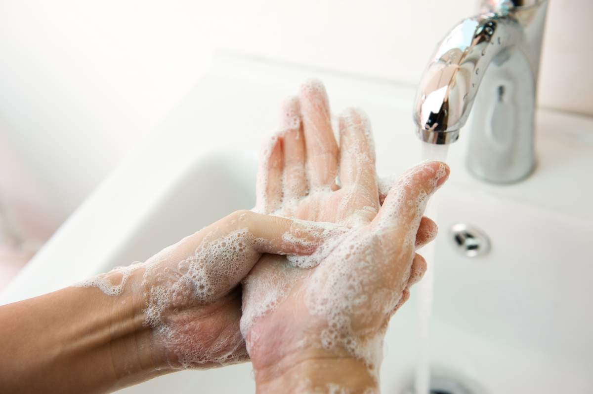 person washing hands with soap and water