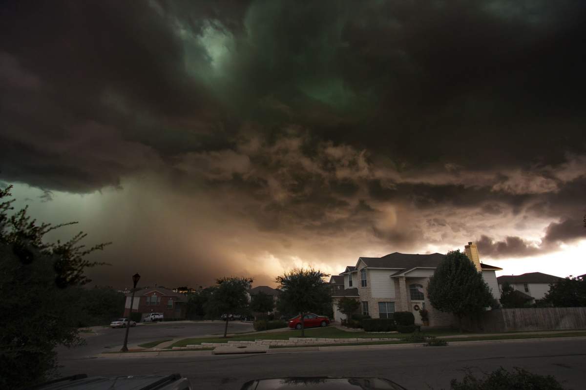 Large storm clouds hover over a small house