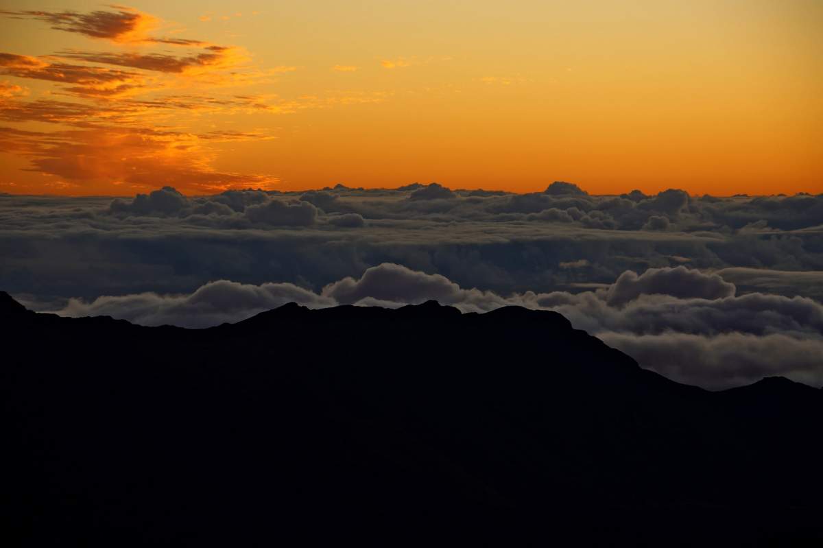 An image of a sunrise, clouds, and Haleakal, Maui
