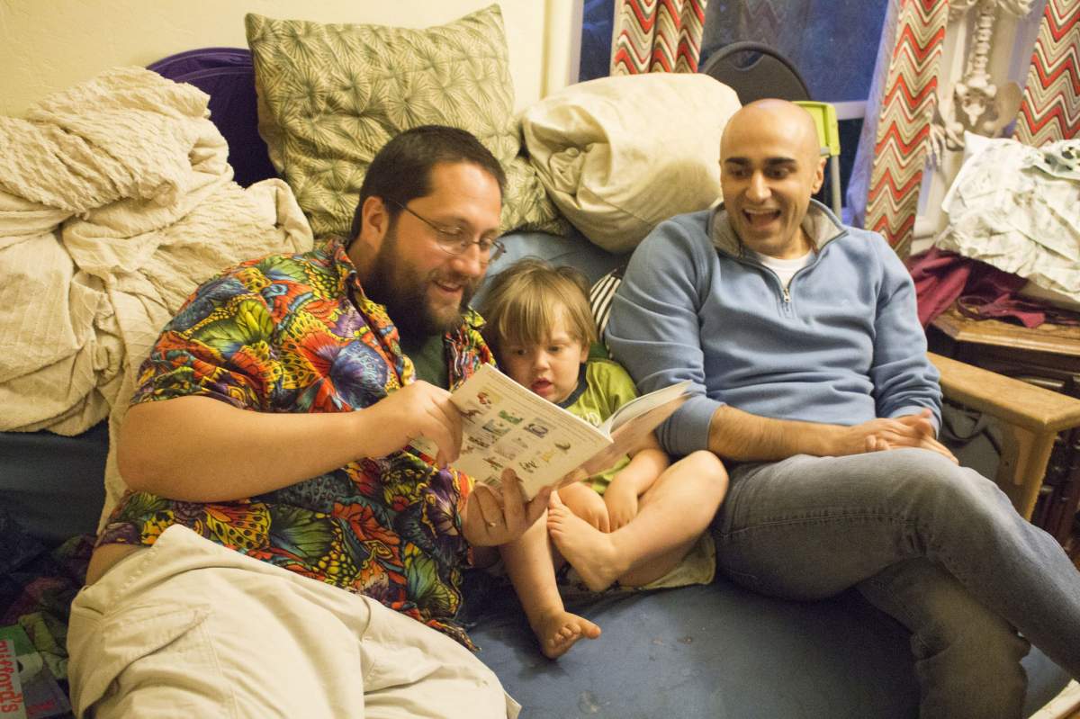 a child being read a story by two men