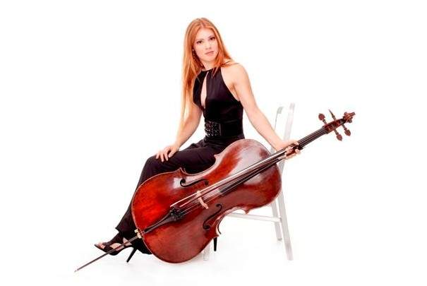 cicely parnas sets on a chair holding her cello close the ground in one hand