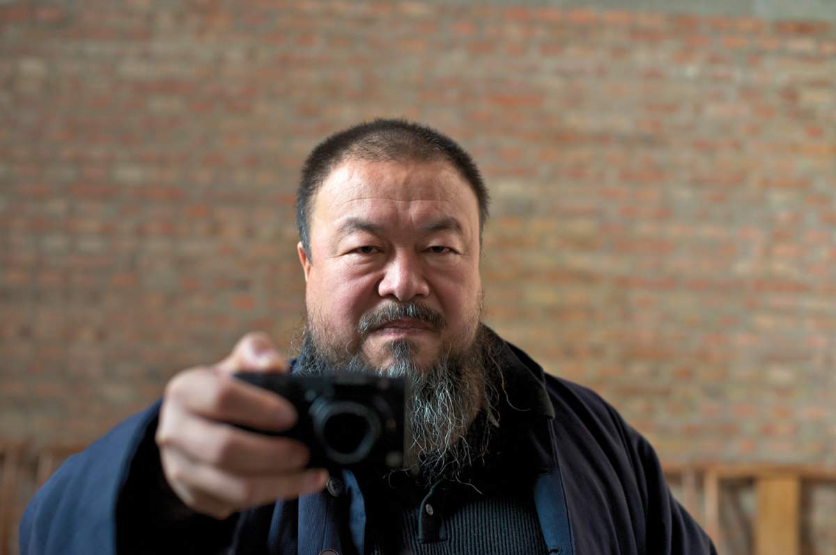 a man holding a camera takes a self portrait