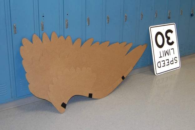 cardboard wings, traffic sign, against school lockers