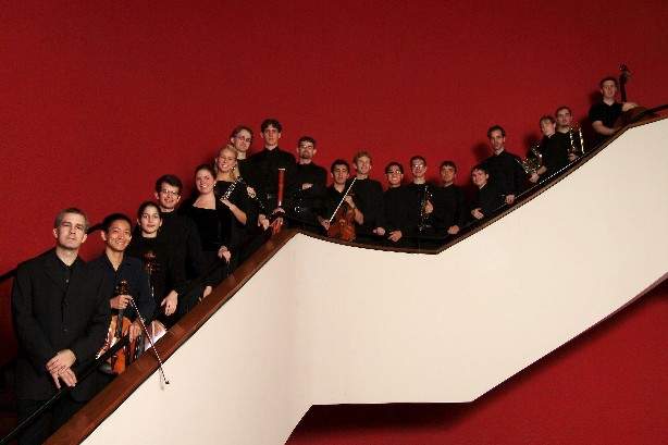 A group of musicians stand on a staircase