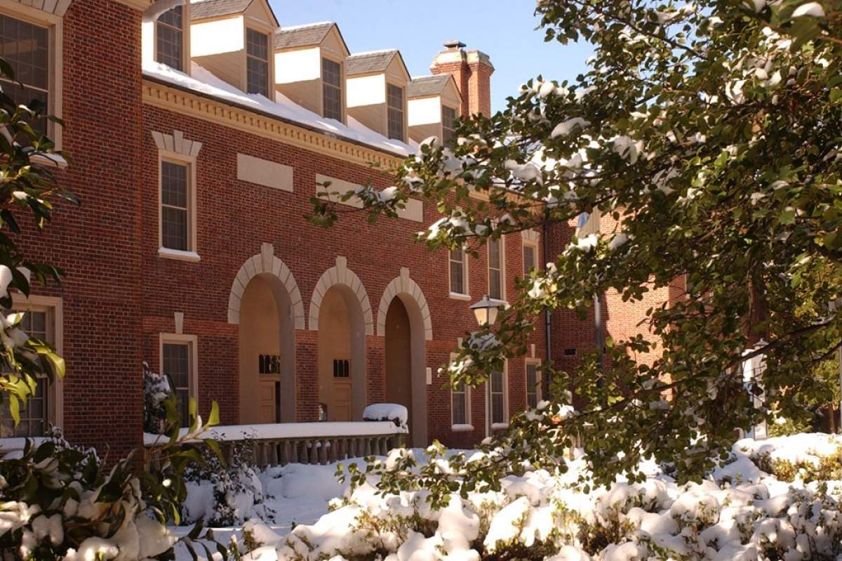 A brick building is surrounded by snow covered trees