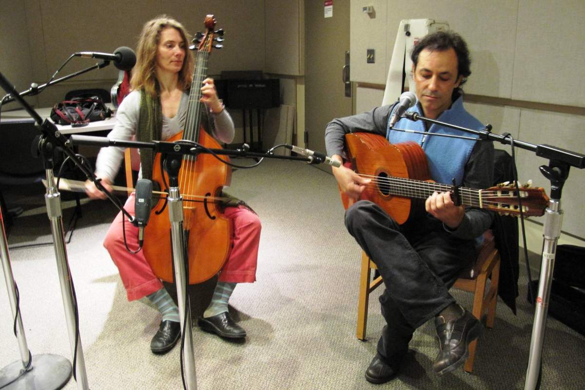 a woman plays a viola da gamba and a man plays a guitar