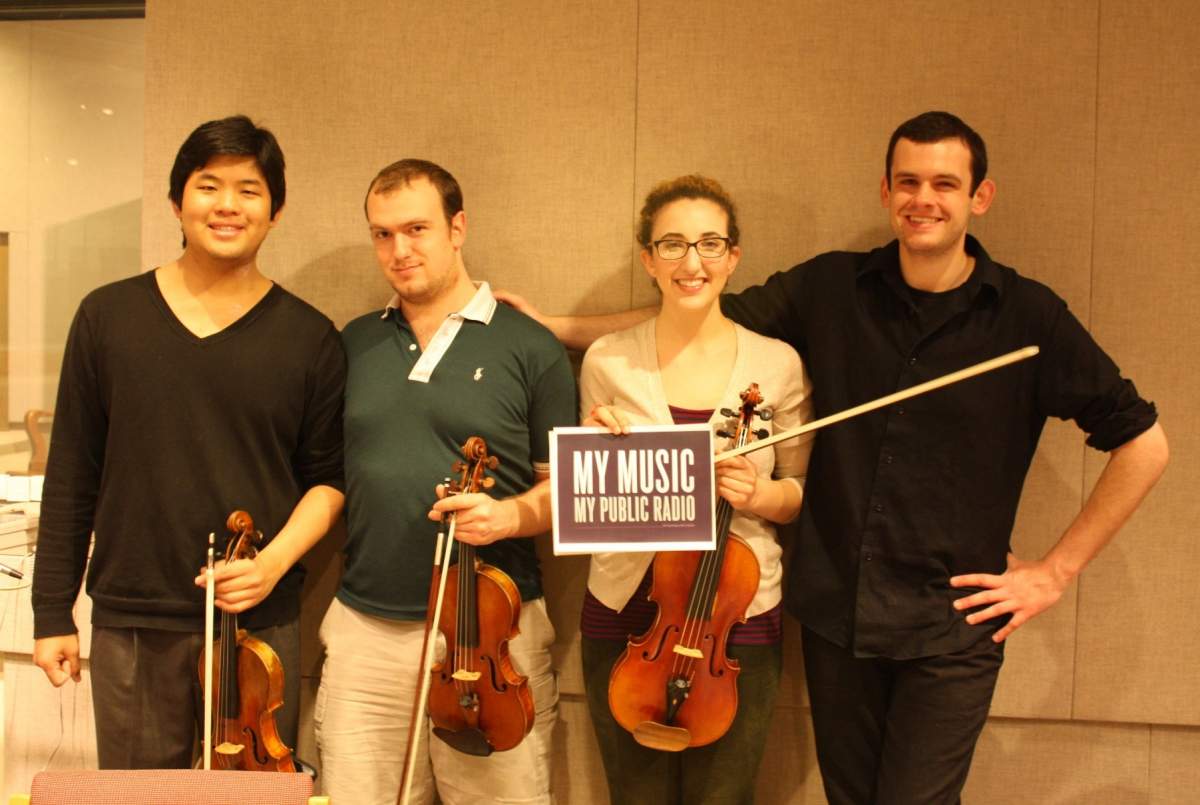 the string quartet poses with a sign reading My Music My Public Radio