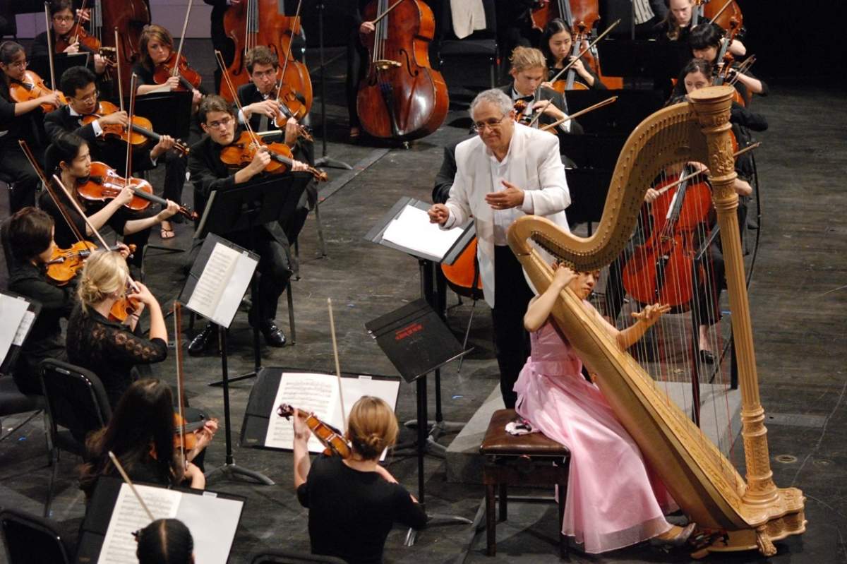a harpist performs with an orchestra