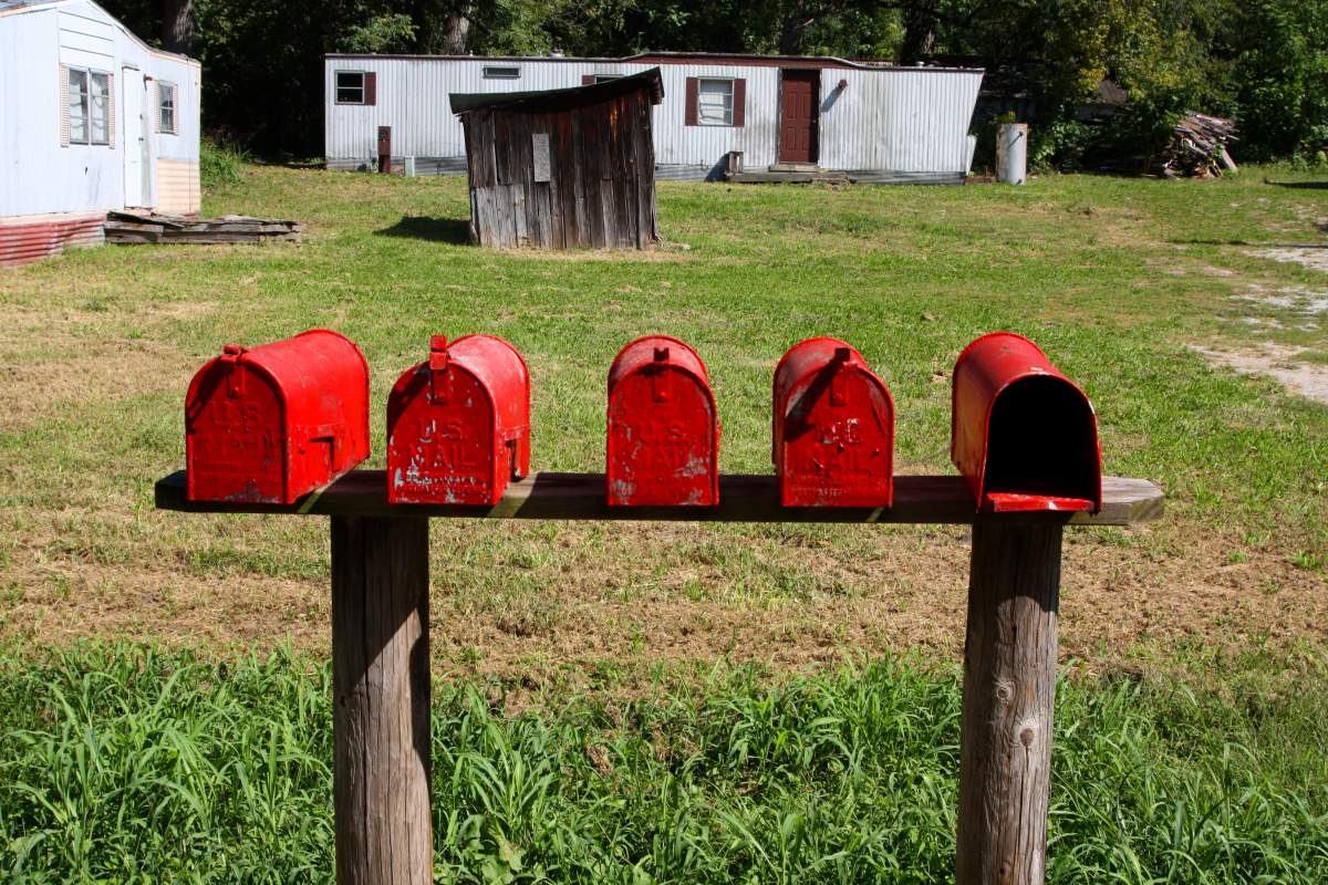 photo of five red mailboxes with trailers in background