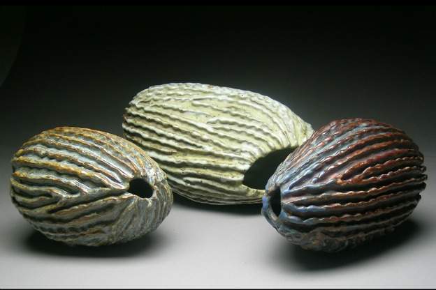 three hollow vessels with striated exteriors, in the shape of seed pods