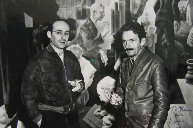 Harry Engel and Thomas Hart Benton pose in front of Benton's mural panel featuring a portrait of Hoosier Group painter William Forsyth, in Bloomington, October 1940 or March 1941.