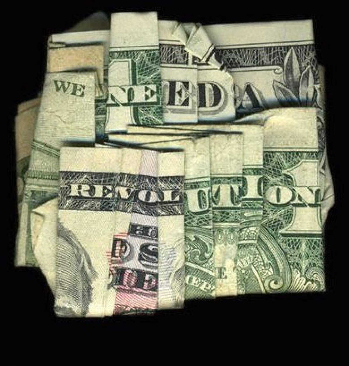 Dollar bills folded to read "We need a Revolution"