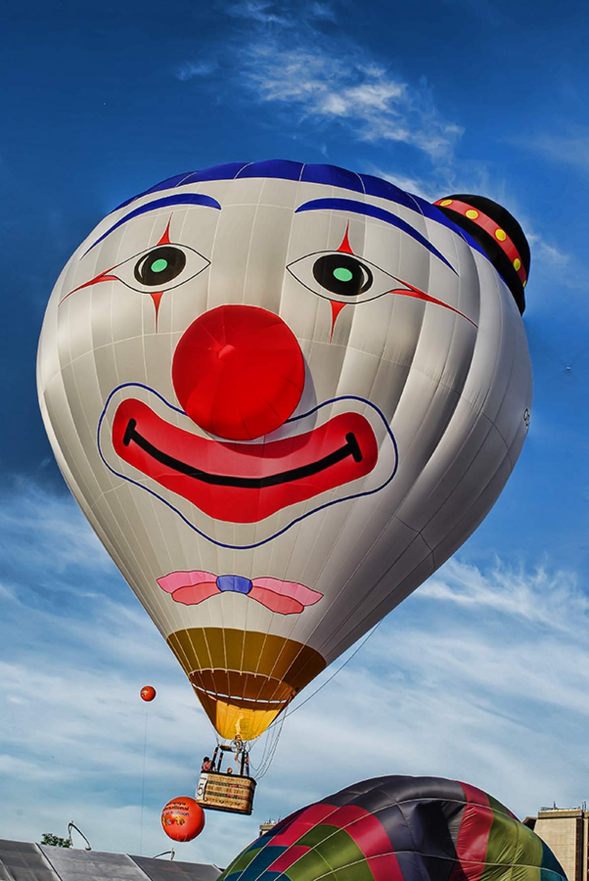 A smiling clown shaped hot air balloon