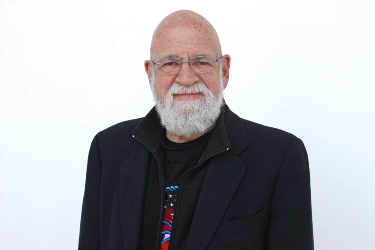 Jeremy Kagan wearing frameless glasses, gray beard, dressed in black suit jacket over black sweater and colored T-shirt.