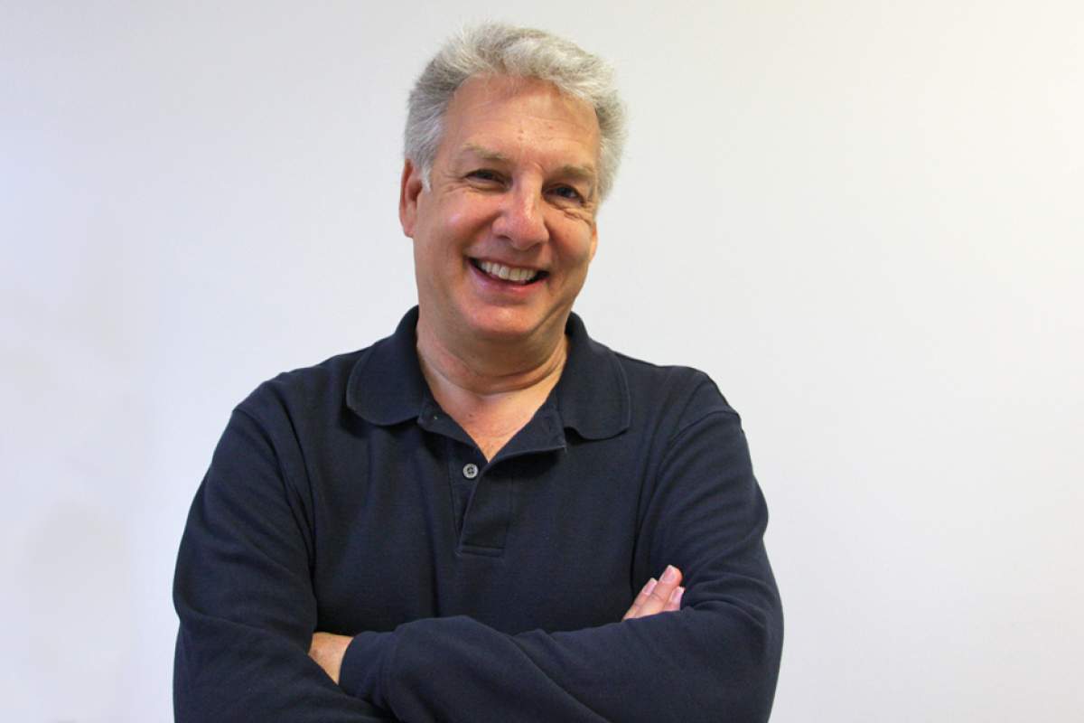 Marc Summers in black polo shirt, smiling, arms crossed across chest.