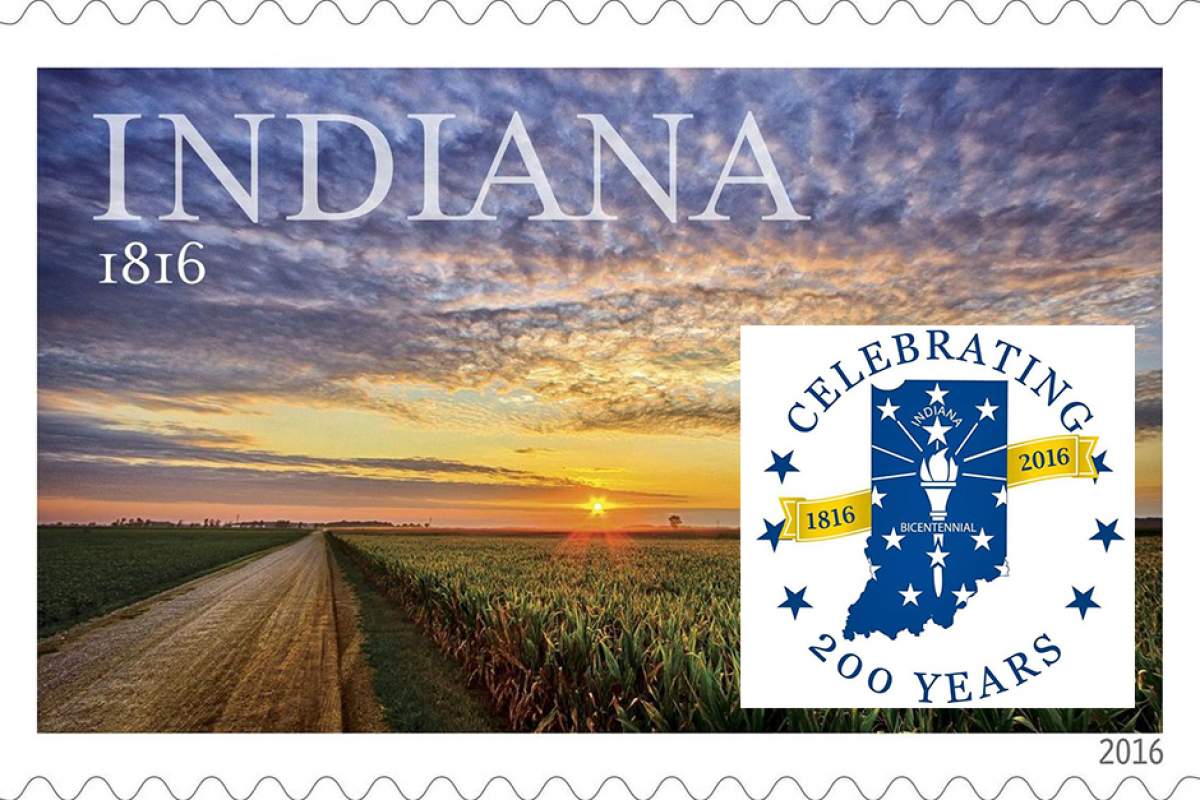 The 20a6 Indiana Bicentennial stamp showing a road and farmlands at sunset, with the logo of Indiana's Bicentennial superimposed.