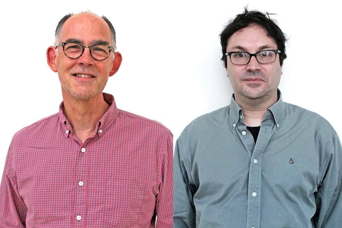 Kevin Dettmar in a red and blue checked shirt; Eric Weisbard in solid gray shirt worn over a black T-shirt. Both men wear horn-rimmed classes.