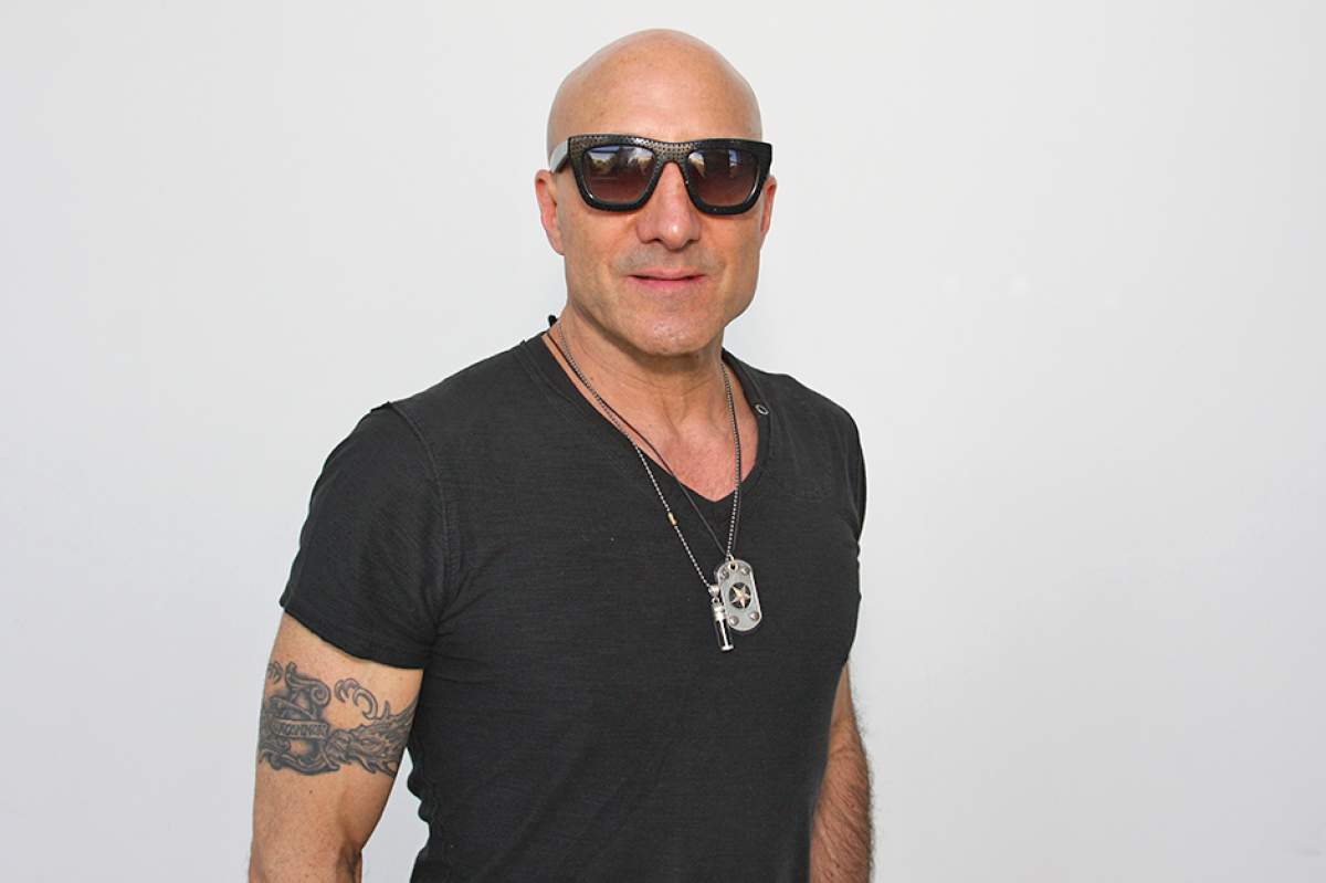 Kenny Aronoff in dark sunglasses, black T-shirt, with tattoo on right arm.