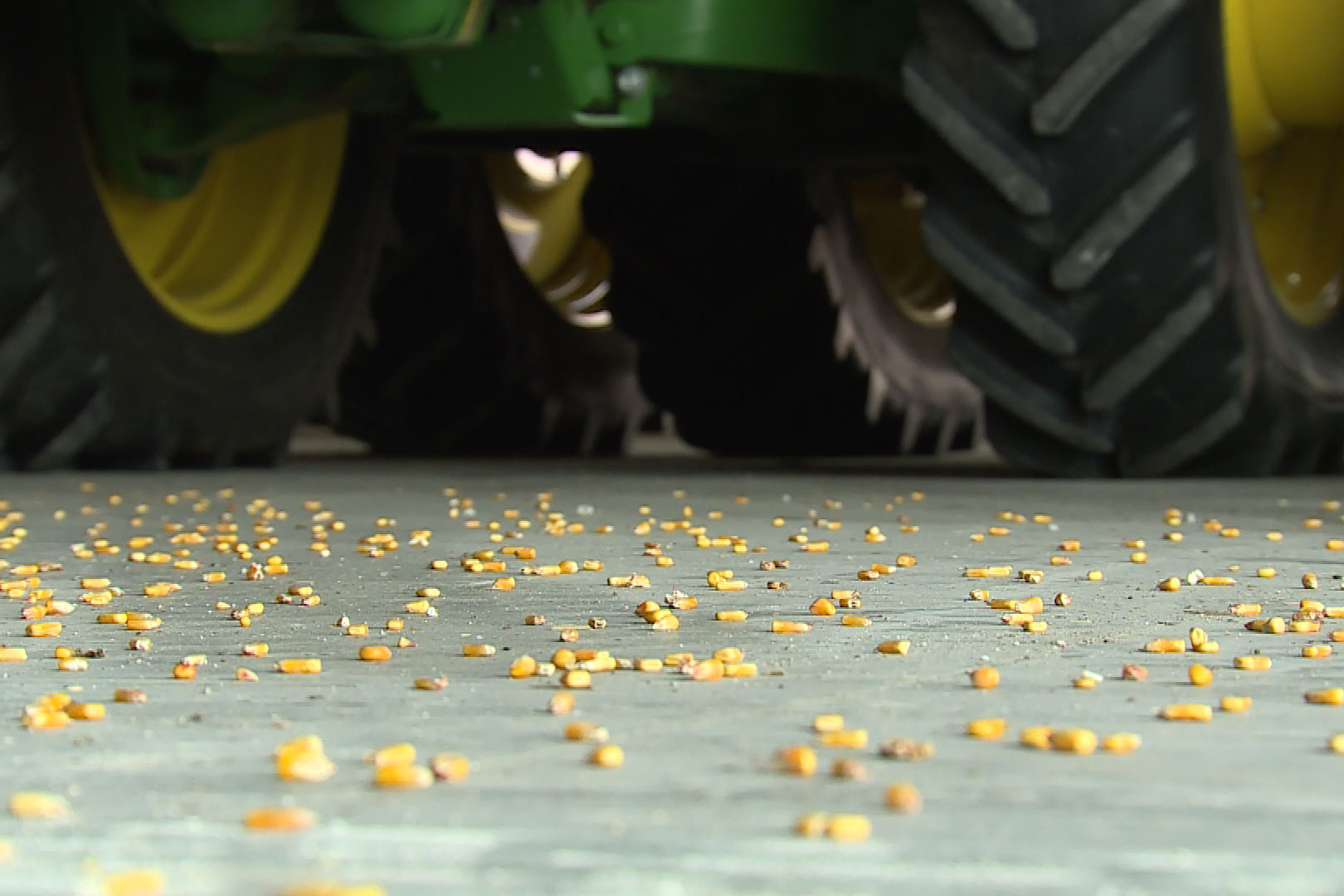 corn on a garage floor with farm equipment in background