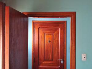 An open wooden door looks onto a closed door framed across the hall