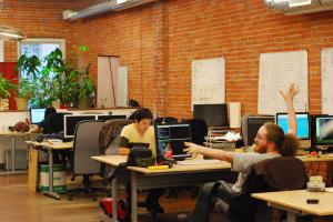 Coworkers sit at their desks in a communal work environment