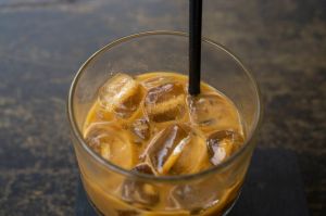 An iced coffee with a straw on a wooden table