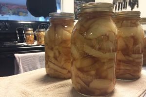 Quart canning jars with apple pie filling on a table. 