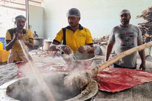 Workers pound the steaming haleem
