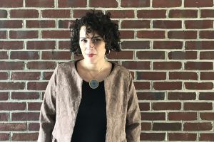 color photo of Christine Folch standing in front of a brick wall