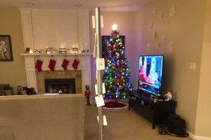 A freestanding pole with post-it notes, in a house, with a Christmas tree in the background