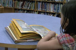 Young girl reading in library