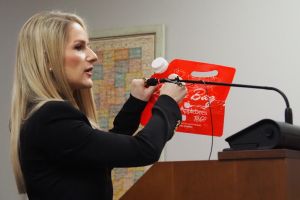 Abbi Raben, representing the Indiana Restaurant & Lodging Association, holds up an example of a tamper-evident container for carry-out alcohol in committee on Tuesday, Jan. 23, 2024.