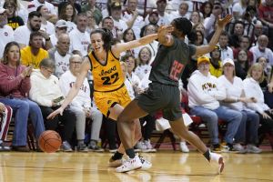 OK TO USE — Iowa's Caitlin Clark (22) is defended by Indiana's Chloe Moore-McNeil (22) during the first half of an NCAA college basketball game, Thursday, Feb. 22, 2024, in Bloomington, Ind.