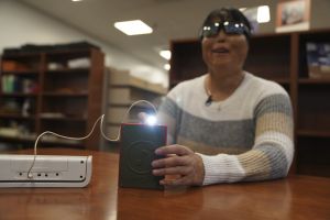 AP OK Minh Ha, assistive technology manager at the Perkins School for the Blind tries a LightSound device for the first time at the school's library in Watertown, Mass., on March 2, 2024. As eclipse watchers look to the skies in April 2024