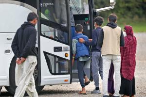 Afghan evacuees boarding a bus