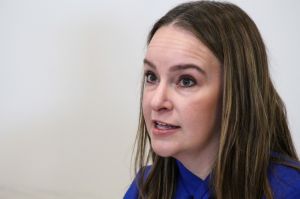 Indiana Medicaid Director Cora Steinmetz speaks at a press event. She has brown hair with highlights and wears a blue blouse. 