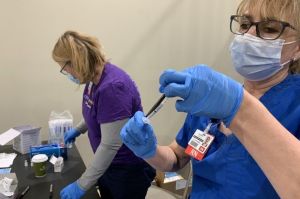 Nurses administer a COVID-19 vaccine