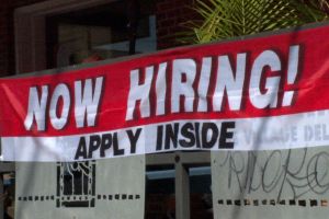 A 'Now Hiring' sign hangs outside the Village Deli restaurant in Bloomington.