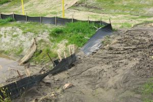 Sediment from a construction site washes over a silt fence and into a waterway.